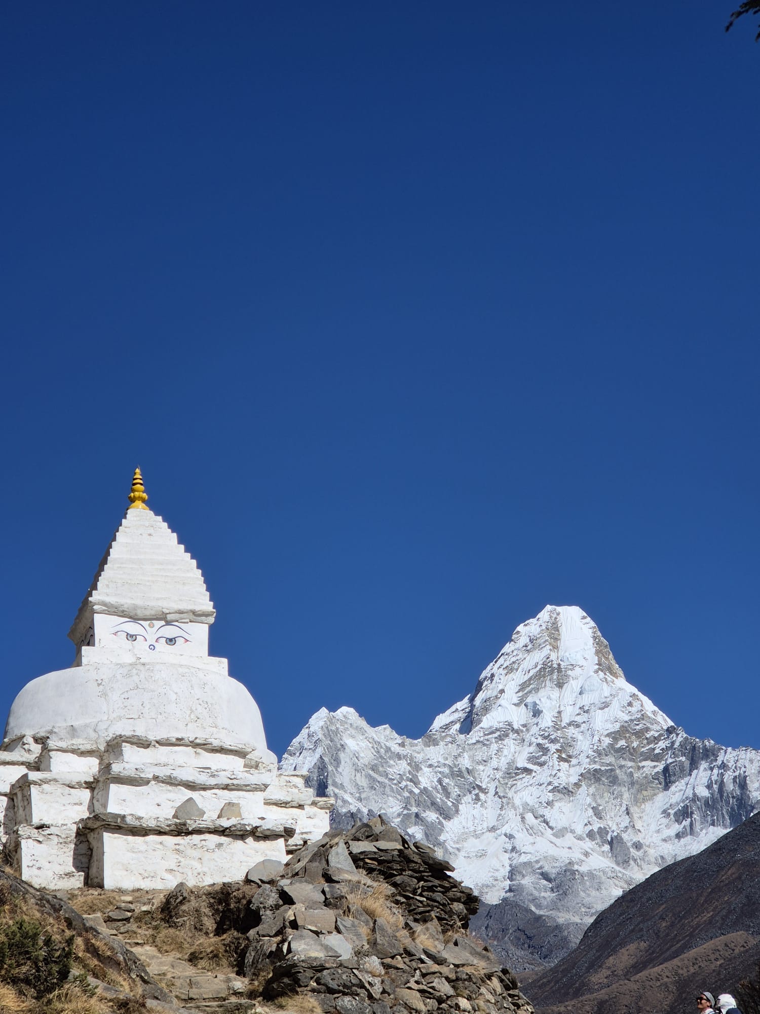 Beautiful white chortens adorned with prayer flags along the Everest Base Camp trail, set against a backdrop of rugged Himalayan peaks.
