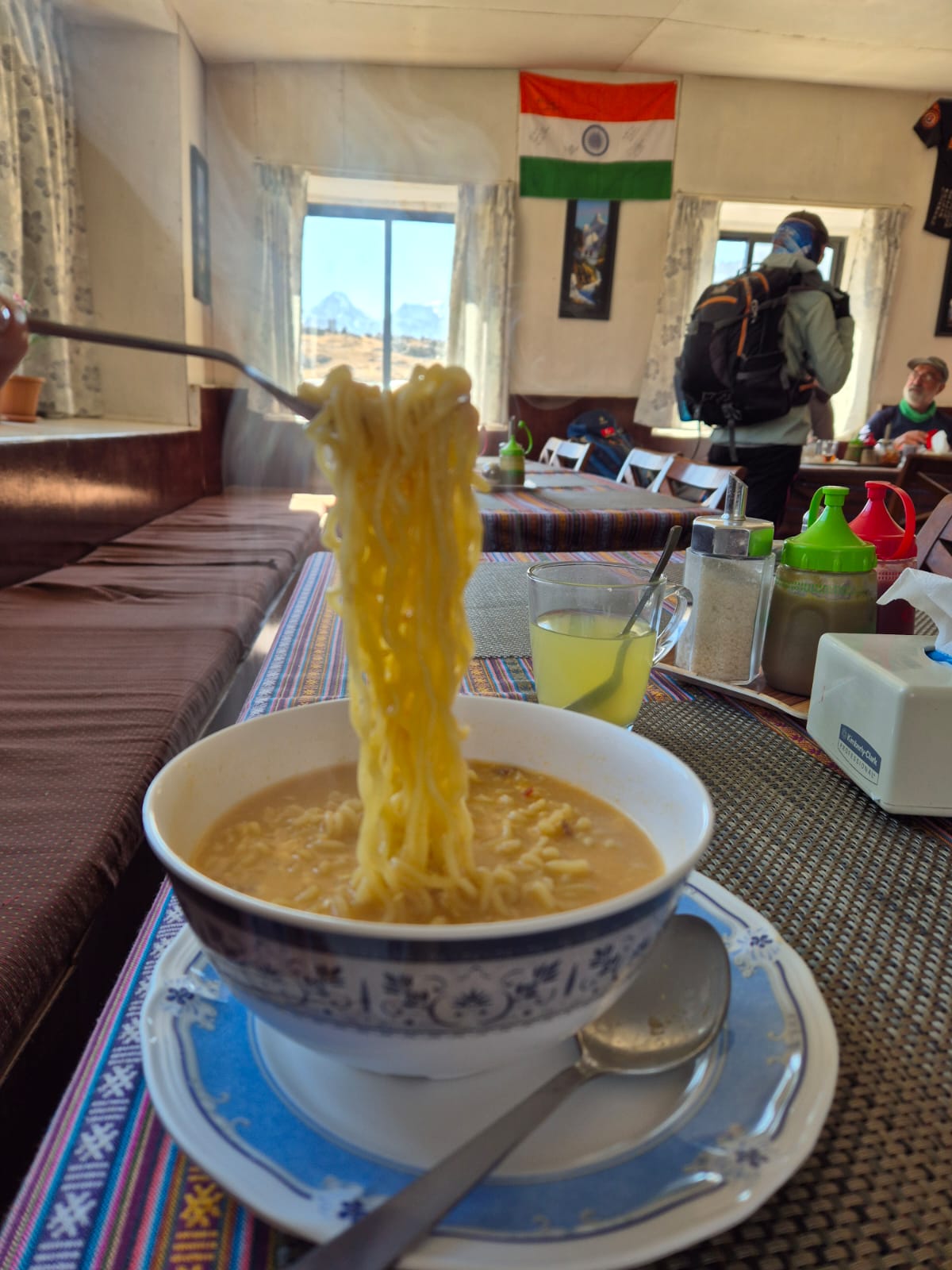 Steaming bowl of noodles served at a teahouse in Everest Base Camp, garnished with vegetables and herbs.