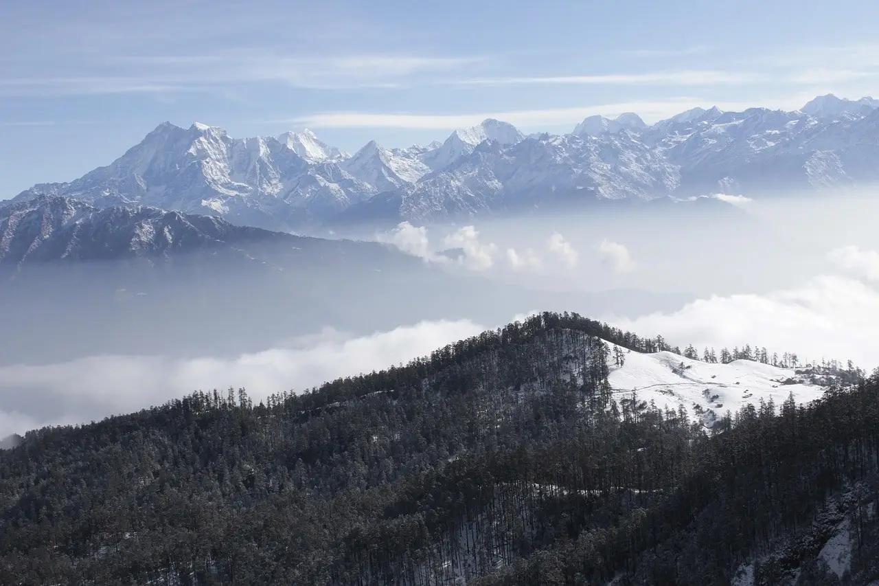 Snow-covered mountains and hills surrounding Kuri Village, creating a serene winter landscape.